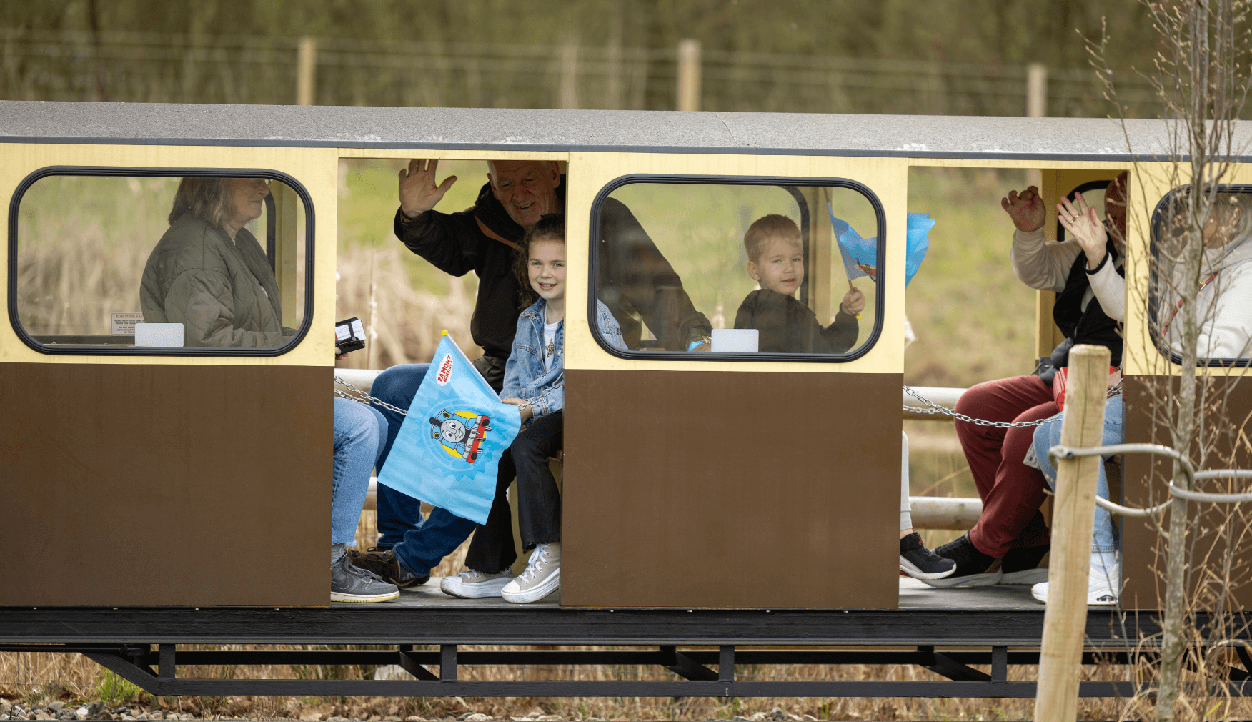 Families waving from train carriages at Statfold Day Out With Thomas