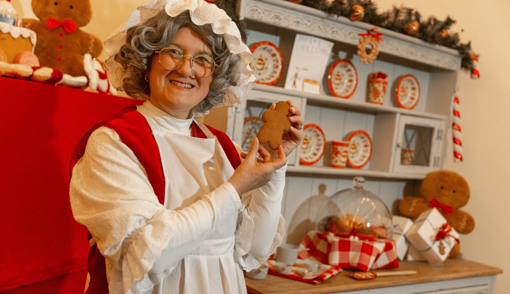 Mrs Claus holding gingerbread in the bakery